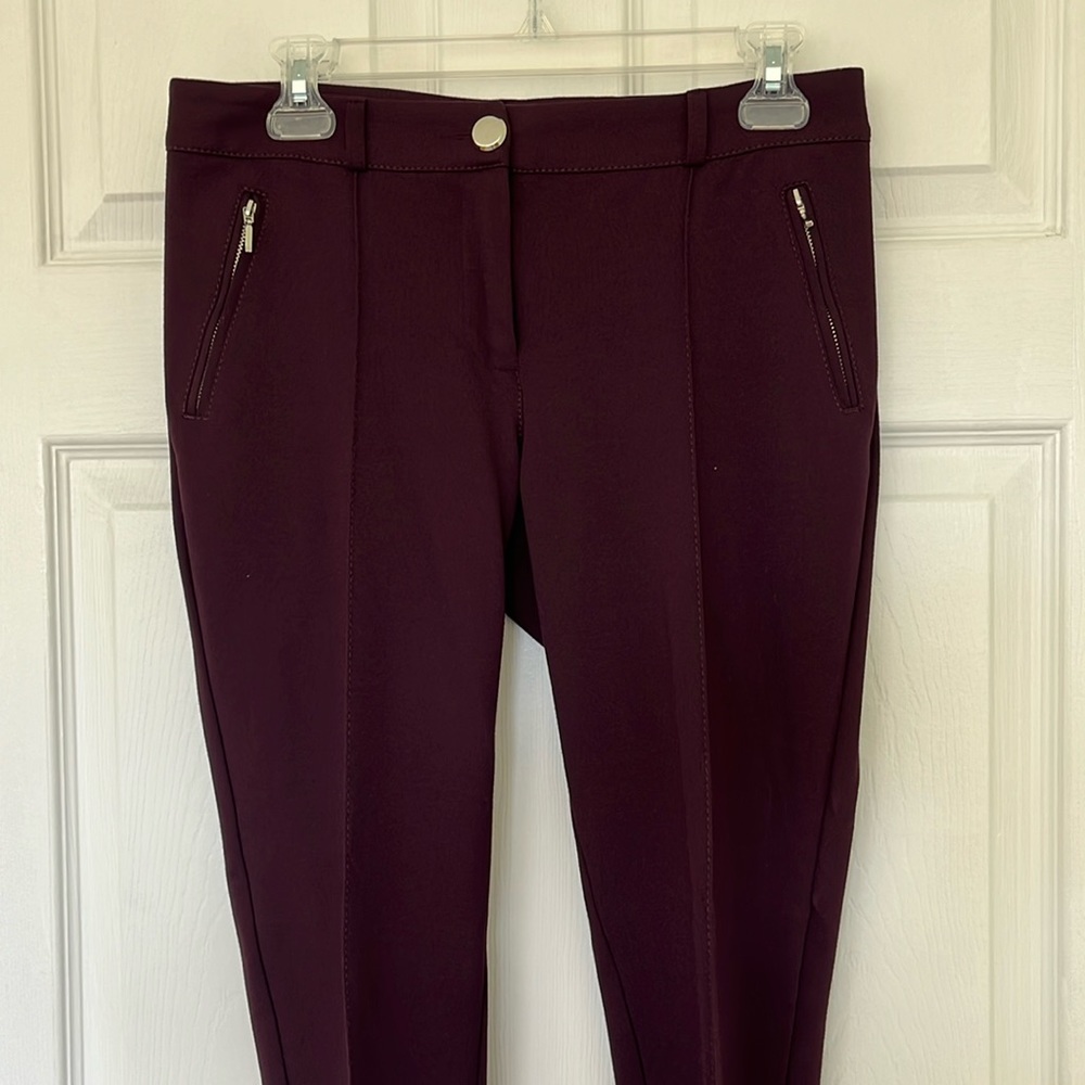 Wallis dark plum colored pants with stitched seam and front zip pocket detail.
